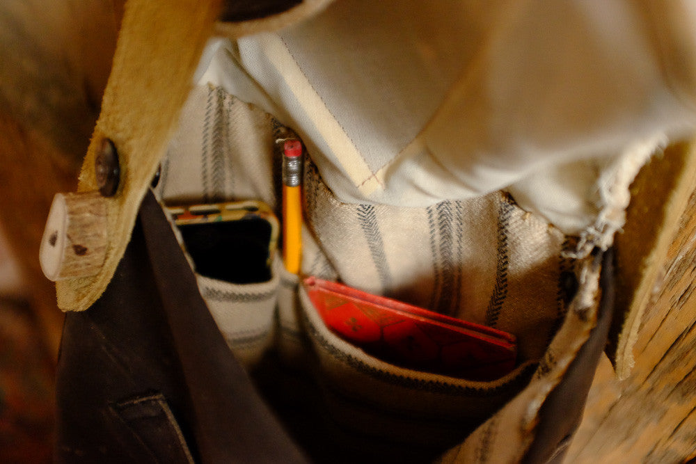 Canvas and suede shoulder bag for tablet storage and outdoor use.