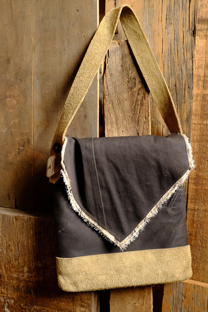 Canvas and suede shoulder bag for tablet storage and outdoor use.
