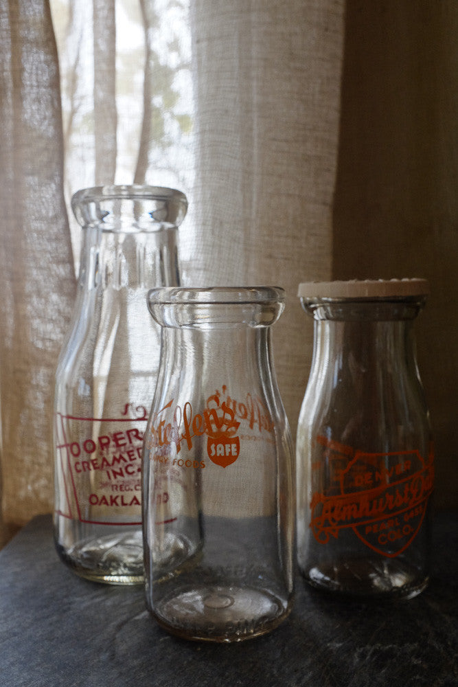 Three vintage milk bottles with one cap - Antares Furnishings